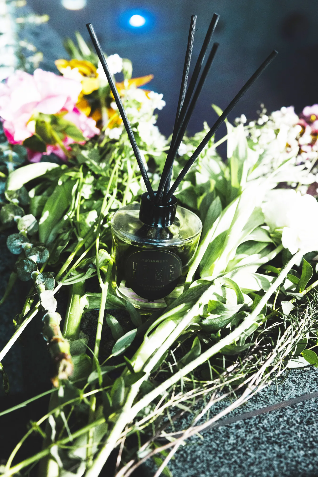Home fragrance with reeds among flowers